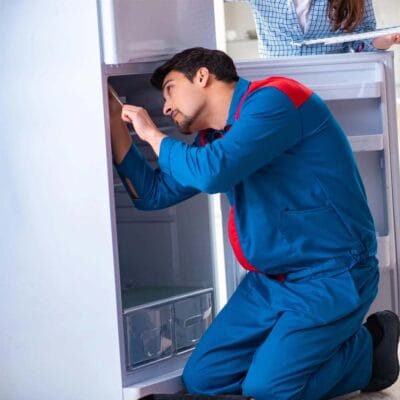 Thợ đang sửa tủ lạnh cho khách hàng
